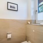Badezimmer mit Fenster, Toilette und Wandbild