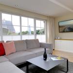 Wohnzimmer mit Sofa, Couchtisch und Fernseher an der Wand.