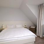 Schlafzimmer mit Doppelbett, Nachttischen und Fenster mit Blick.