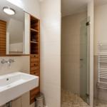 Bathroom with shower, sink, and towel heater