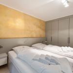 Bedroom with double bed, nightstand, and wardrobe against the wall.