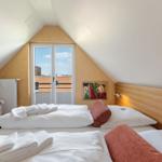 Zimmer mit Doppelbett, Sessel und Fenster zur Aussicht.