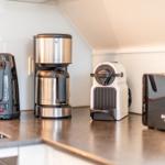 Küchenzeile mit Kaffeemaschine, Kaffeekanne und Toaster.