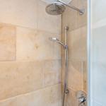 Dusche mit Steinwand und Duschbrause