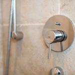 Duschbrause mit Chromarmatur an Steinwand