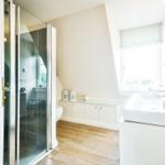 Bathroom with shower, sink, and window