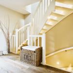 House with stairs, basket, and decor on the wall.