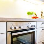 Kitchen with stainless steel stove, wooden countertop, and plants on the work surface.