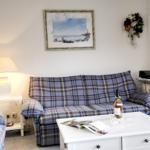 Living room with sofa and coffee table. Wall picture and lamp are visible.