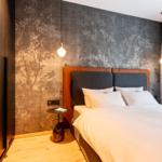 Schlafzimmer mit Bett, Wandtapete und Nachttisch