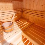 Holzsauna mit Sitzbänken und Eimer. Markenname KLAFS sichtbar.