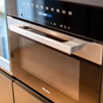 Ein eingebautes Miele-Küchenherd mit Touchdisplay und Edelstahlgriff.