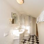 Badezimmer mit Dusche, Waschbecken und Handtuchhalter.