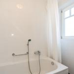 Bad mit Badewanne, Duschkopf und Fenster