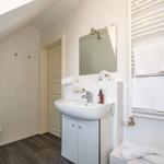 Badezimmer mit Waschbecken, Spiegel, Toilette und Handtuchheizung.
