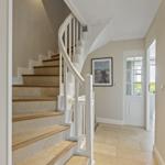 Eingangsbereich mit Treppe und Tür zum Wohnbereich.