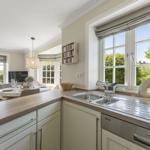 Küche mit Arbeitsplatte, Spüle und Fenster zum Garten.