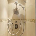 Dusche mit Duschbrause, Handbrause und Sonnenmotiv auf Wandfliese.