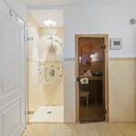 Dusche mit Sonnenmotiv, Sauna und Handtuchwärmer im Badezimmer.