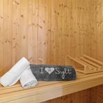 Sauna mit Holzwand und Handtüchern auf der Bank
