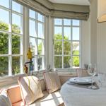 Rundes Tisch mit Stuhl, Fensterbank mit Kissen und dekorativen Gegenständen.