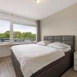 Bedroom with double bed, large window, and balcony view.