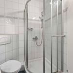 Bathroom with shower, toilet, and sink.