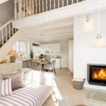 Living room with sofa, fireplace, and staircase to a gallery
