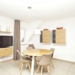 Esszimmer mit runden Tisch, Stühlen, Küchenschränken und Fernseher an der Wand.
