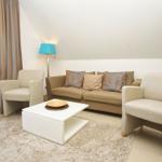 Living room with sofa, two chairs, table, and window.