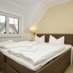 Bedroom with double bed, window, and nightstand.