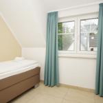 Bedroom with bed, window, and curtains