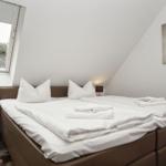 Bedroom with double bed, window, and wall art.
