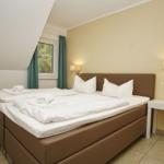 Schlafzimmer mit Doppelbett, Fenster und Nachttisch