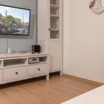 Wohnzimmer mit Fernseher, Sideboard und Bücherregal. Wanddekoration mit Anker.