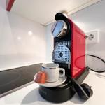 Roter Kaffeemaschine mit Tasse und Kapsel auf Küchenarbeitsplatte