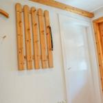 Wall with wooden coat rack, door, and window with curtain.