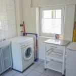 Apartment with washing machine, sink, and refrigerator.