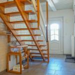 Haus mit Holztreppe, weiße Ziegelwand und Kindersitz