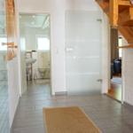 Haus mit Holztreppe, Glaswand und Bad im Flur