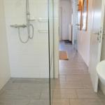 Bad mit Dusche, Waschbecken und Handtuchhalter.
