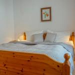 Ein Schlafzimmer mit Holzbett, zwei Nachttischen und Wandbildern.