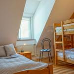 Schlafzimmer mit Doppelbett und Kletterkorb. Holzbett, Fenster und Stuhl.