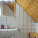 Badezimmer mit Waschbecken, Spiegel und Holzdecke