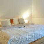 A bedroom with a wooden bed, a quilt, and two nightstands with lamps.