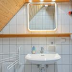Bathroom with sink, mirror, and wooden ceiling.