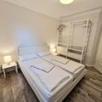 Schlafzimmer mit Doppelbett, Kleiderschrank und Nachttischen.