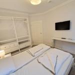 Schlafzimmer mit Doppelbett, Kleiderschrank und Wand-TV