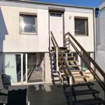 Haus mit Außentreppe, Terrasse und Glasfront zur Garage.