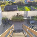 Terrasse mit Sitzgruppe, Tisch und Stufen zum Garten.